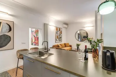 a kitchen with a sink and a living room at 3 bedroom apartment Via Genova Monti area in Rome