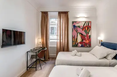 a hotel room with two beds and a desk at 3 bedroom apartment Via Genova Monti area in Rome