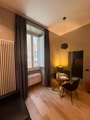 a living room with a table and a window at Augusto Imperatore Luxury Suite in Rome