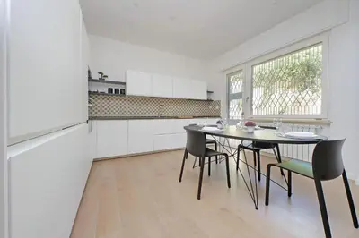 a white kitchen with a table and chairs at YCH-La tua casa dei sogni al Vaticano in Rome