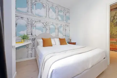 a white bed with orange pillows in a room at YCH-La tua casa dei sogni al Vaticano in Rome