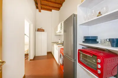 a kitchen with a red toaster oven on a refrigerator at Conti Ripetta house in Rome