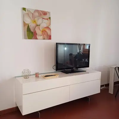 a white dresser with a tv on top of it at Conti Ripetta house in Rome