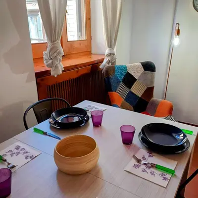 a table with black plates and purple glasses on it at Conti Ripetta house in Rome