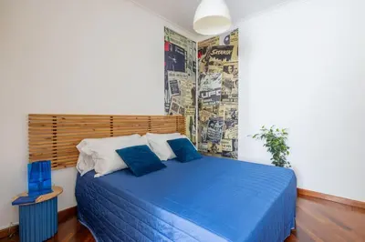 a bedroom with a blue bed with a wooden headboard at STRACULT HOUSE Suggestive and Vintage-pop Apartment in Rome
