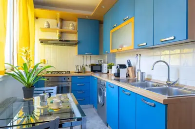 a kitchen with blue cabinets and a glass table at STRACULT HOUSE Suggestive and Vintage-pop Apartment in Rome