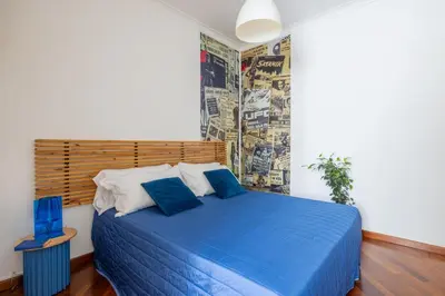 a bedroom with a blue bed with a wooden headboard at STRACULT HOUSE Suggestive and Vintage-pop Apartment in Rome