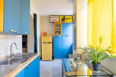 a kitchen with blue cabinets and a yellow refrigerator at STRACULT HOUSE Suggestive and Vintage-pop Apartment in Rome