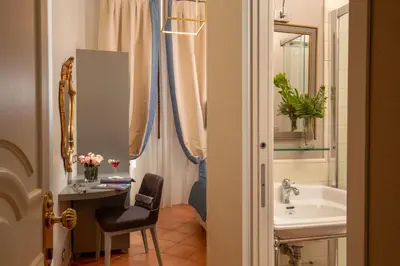 a bathroom with a sink and a desk with a chair at Hotel Mozart in Rome