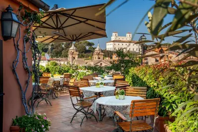a patio with tables and chairs and a building at Hotel Mozart in Rome