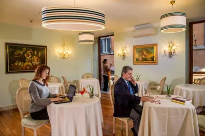 a man and woman sitting at a table in a restaurant at Hotel Mozart in Rome