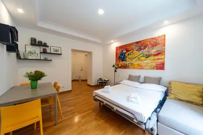 a bedroom with a bed and a desk and a painting at Flaminio District Holiday Home in Rome