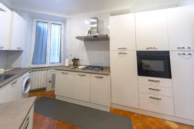 a kitchen with white cabinets and a stove top oven at Flaminio District Holiday Home in Rome