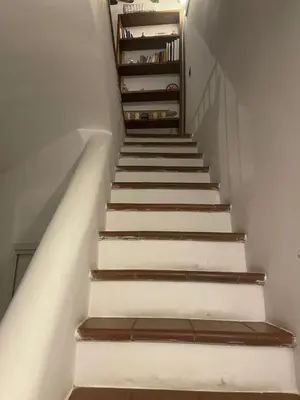 a staircase with white walls and brown wooden steps at La casa di vasco in Rome
