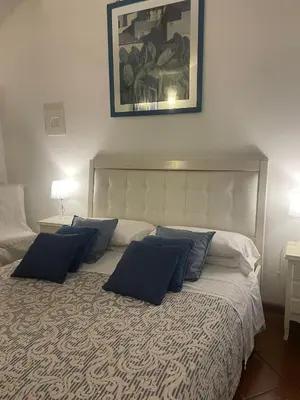 a bedroom with a bed with blue pillows on it at La casa di vasco in Rome