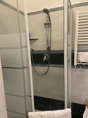 a shower in a bathroom with a glass door at La casa di vasco in Rome