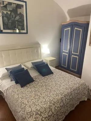 a bedroom with a large bed with blue pillows at La casa di vasco in Rome