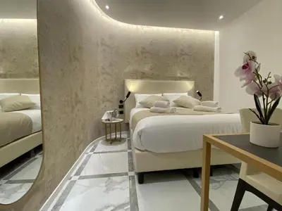 a hotel room with two beds and a table at Suite Croce in Rome