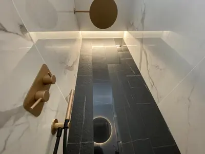 a bathroom with a urinal and a tile floor at Suite Croce in Rome