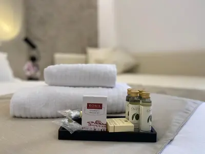 a tray with towels and essential oils on a bed at Suite Croce in Rome