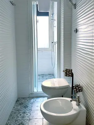 a white bathroom with a toilet and a sink at Cheerful flat in funky Rome in Rome