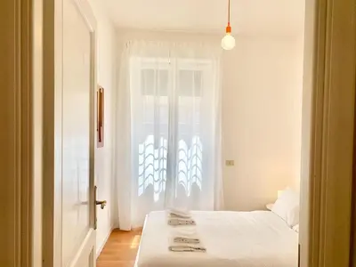 a white room with two beds and a window at RomeAsYouLike - Trastevere Experience 20 in Rome