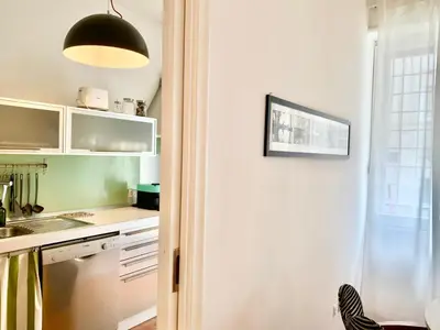 a kitchen with white cabinets and a black light fixture at RomeAsYouLike - Trastevere Experience 20 in Rome