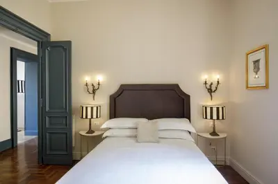 a bedroom with a large white bed with two lamps at Daplace - Lavinia Apartment in Rome