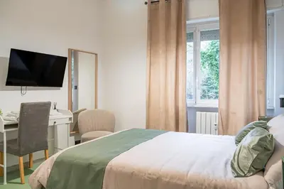 a bedroom with a bed and a desk with a computer at Domus Farnesina Ponte Milvio in Rome
