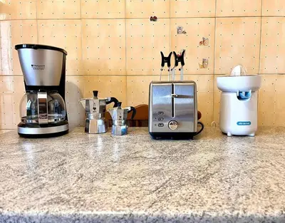 a counter top with a coffee maker and a blender at Green Holiday Penthouse in Rome