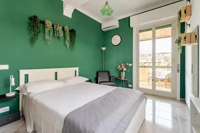 a bedroom with a bed and a green wall at Green Holiday Penthouse in Rome