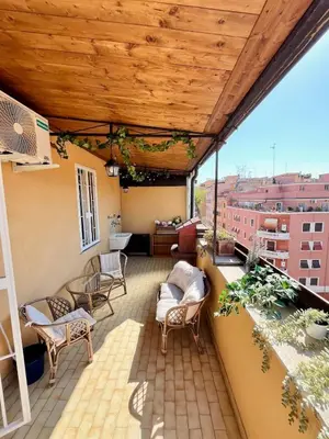 a balcony with a wooden ceiling and chairs at Green Holiday Penthouse in Rome