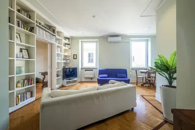 a living room with a couch and a blue chair at PIRAMIDE SHABBY by Casa e Lode - colosseum, air conditioning in Rome