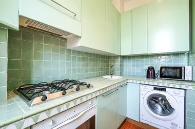 a kitchen with a stove top oven next to a washing machine at PIRAMIDE SHABBY by Casa e Lode - colosseum, air conditioning in Rome
