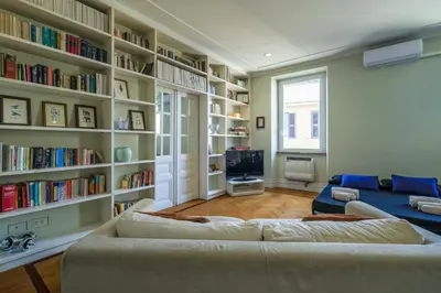 a living room with a couch and book shelves at PIRAMIDE SHABBY by Casa e Lode - colosseum, air conditioning in Rome