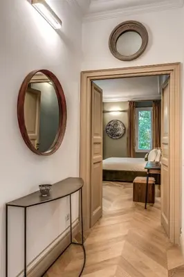 a bedroom with a bed and a mirror and a table at Essenze eleganti a Trastevere in Rome