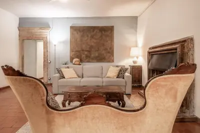a living room with a couch and a tv at Suite Benedetta - Trastevere Luxury in Rome