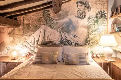 a bedroom with a painting on the wall at Suite Benedetta - Trastevere Luxury in Rome