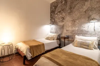 a room with two beds and a stone wall at Suite Benedetta - Trastevere Luxury in Rome