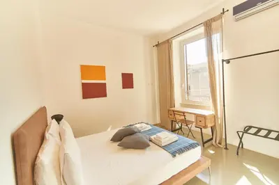 a bedroom with a bed and a window and a desk at Roma Stazione Termini 300 mq appartamento con 4 camere vista e idromassaggio in Rome