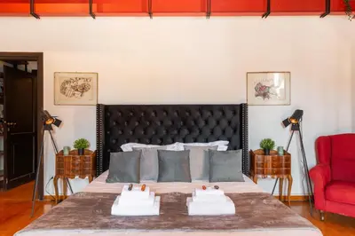 a bedroom with a bed and a red chair at Appartamento con vista piazza Navona in Rome