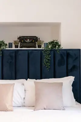a blue headboard with plants on top of a bed at Appartamento con vista piazza Navona in Rome