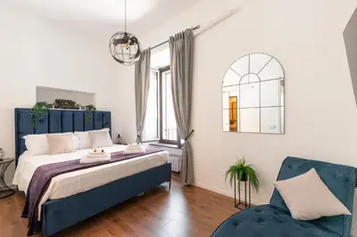 a bedroom with a large bed and a blue chair at Appartamento con vista piazza Navona in Rome