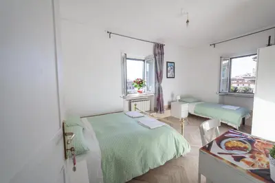 a white room with two beds and a table at Meile House in Rome