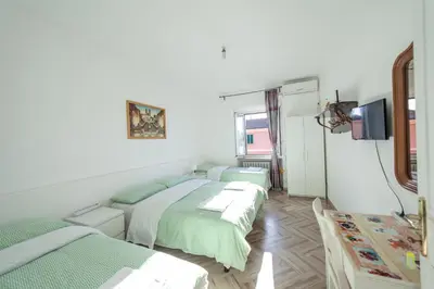 a room with three beds and a tv on the wall at Meile House in Rome