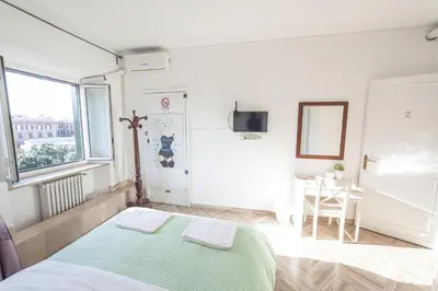 a bedroom with a bed and a table and a window at Meile House in Rome