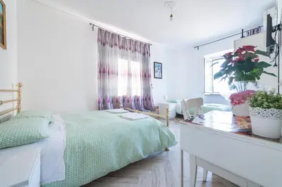 a bedroom with a bed and a desk and a window at Meile House in Rome