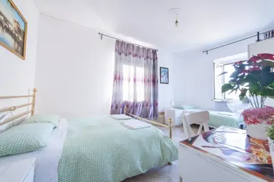 a white bedroom with a bed and a table at Meile House in Rome