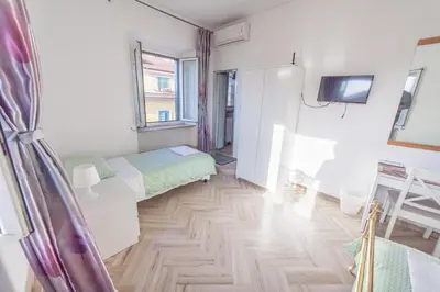 a small room with two beds and a tv at Meile House in Rome