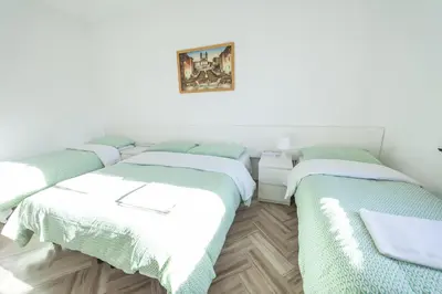 two beds in a room with white walls at Meile House in Rome